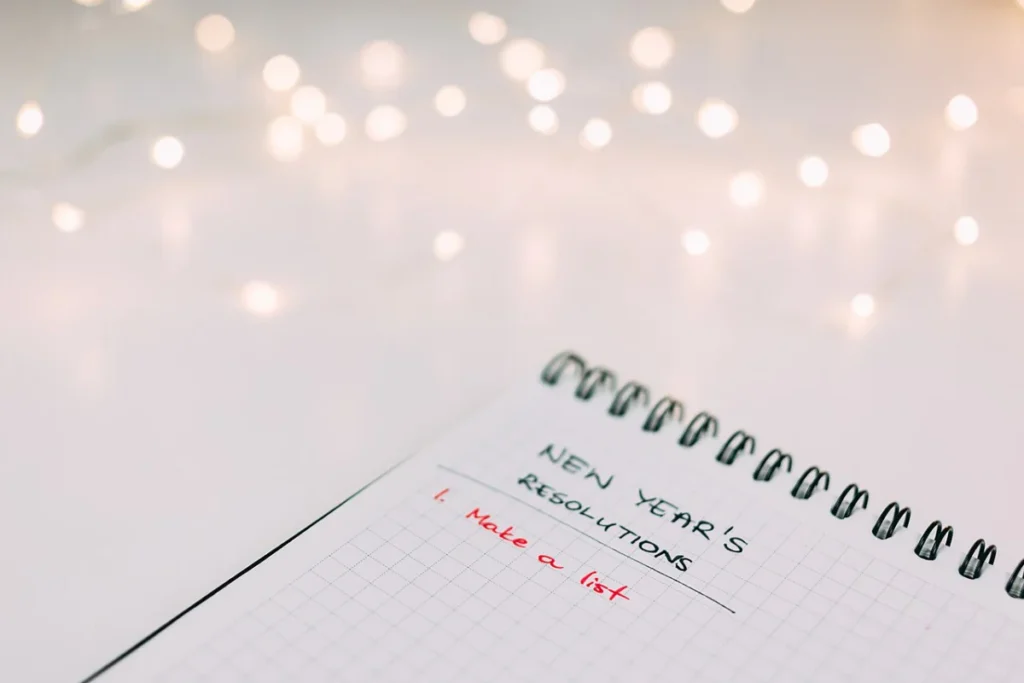 A notebook with page showing new year resolutions list.