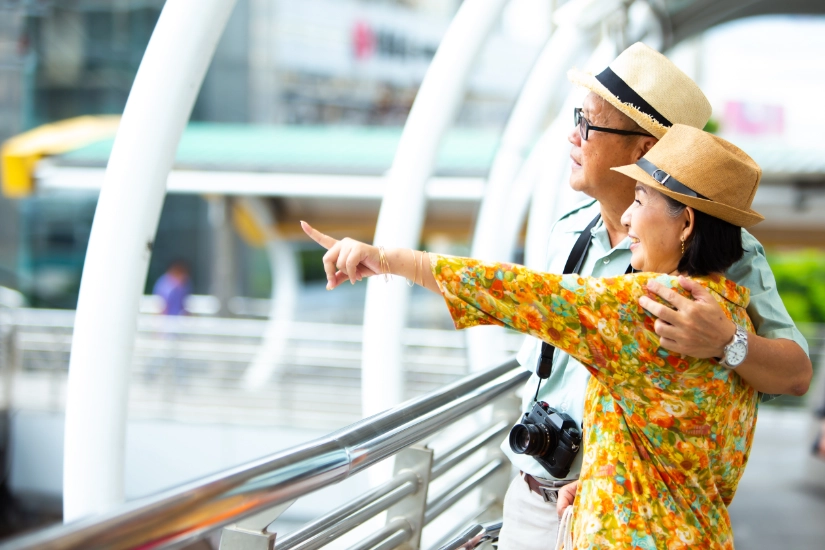 Travel and tourism concept. Happy senior travellers couple with camera in the city retirement trip.