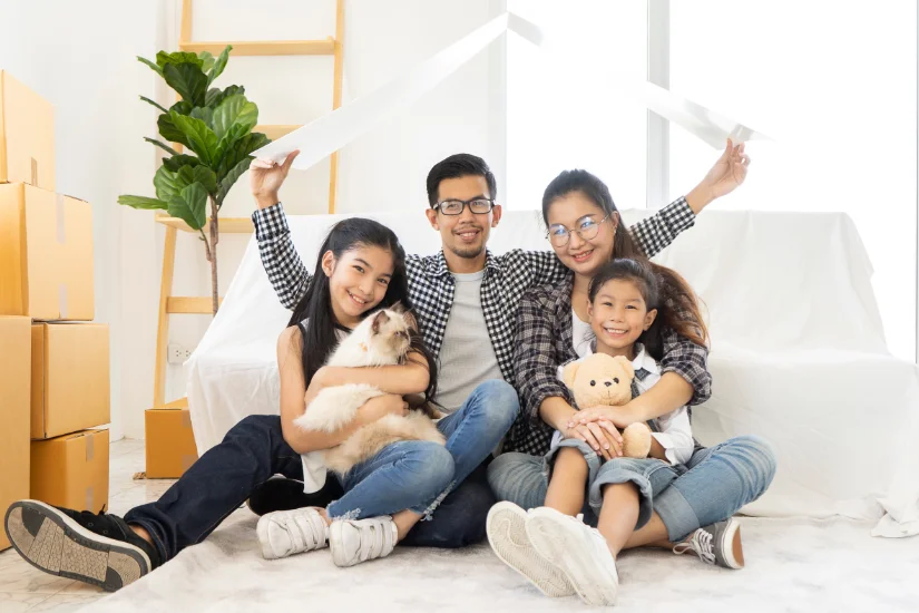 young Asian family team mother, father and children in a new home. concept Starting a family life or housing or rent. Happy Asian Parents Sitting On Floor At new room Playing With children and cat