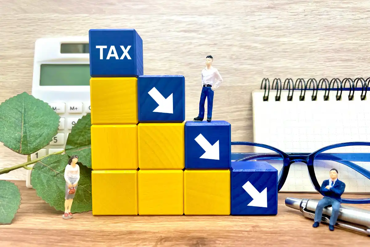 a toy figurine on a stack of blocks symbolize tax reduction